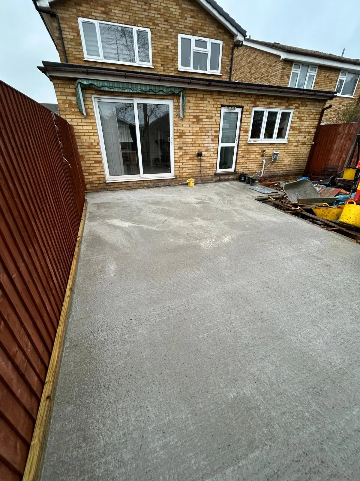 Cured concrete extension base swept clean behind a house ready for the build