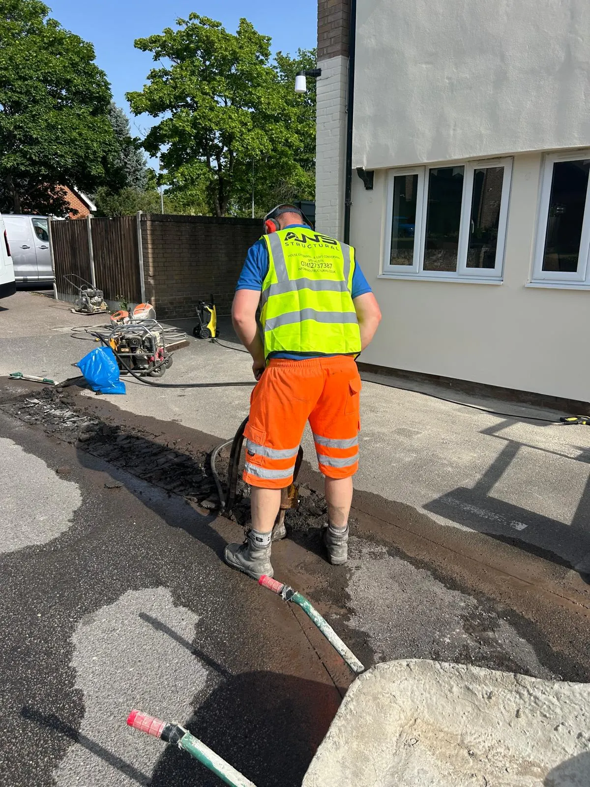 ANS Structural operative in branded hi-vis breaking out concrete for new drainage runs