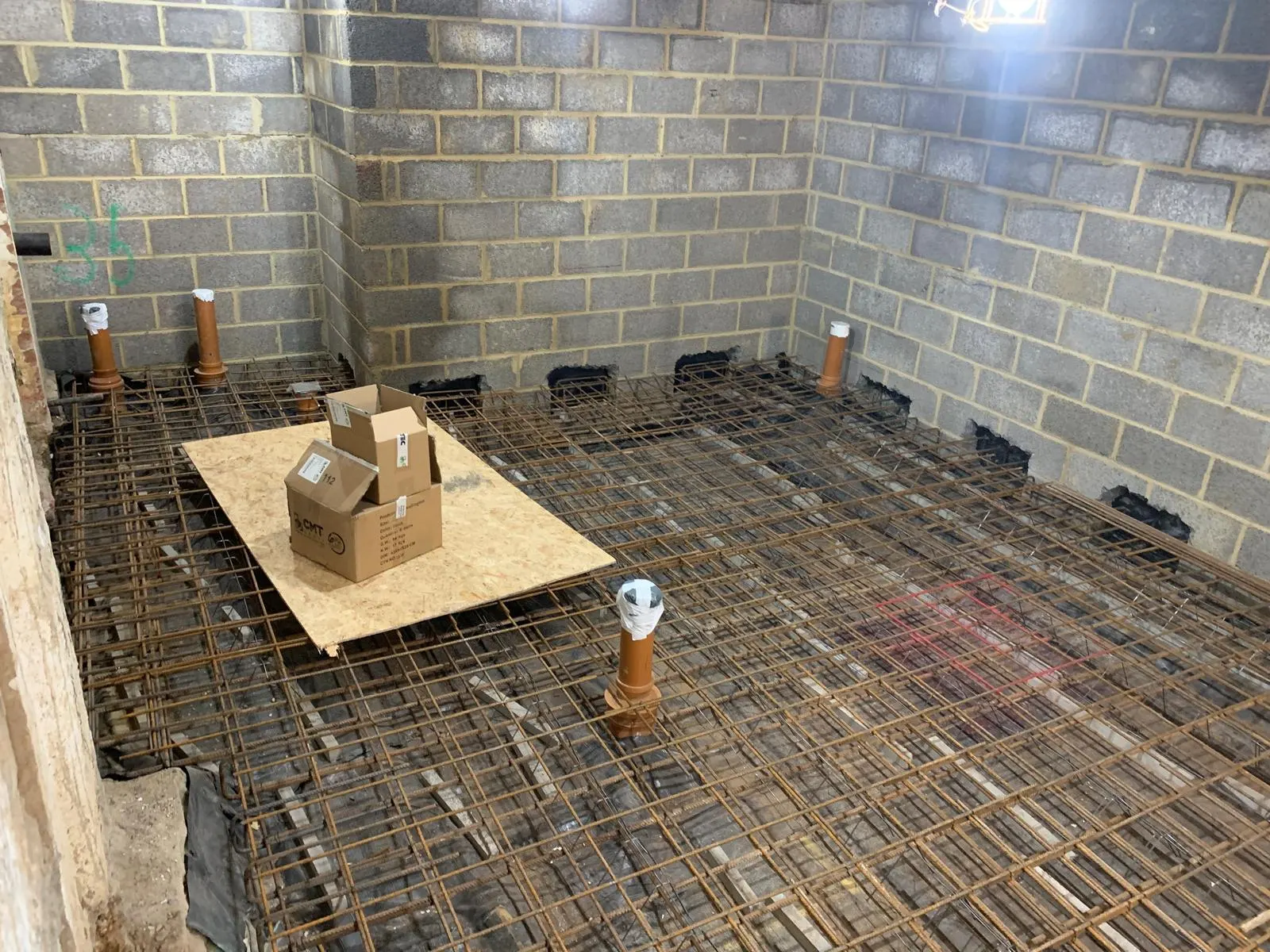 Basement floor covered in hand-tied steel reinforcement before the structural slab pour