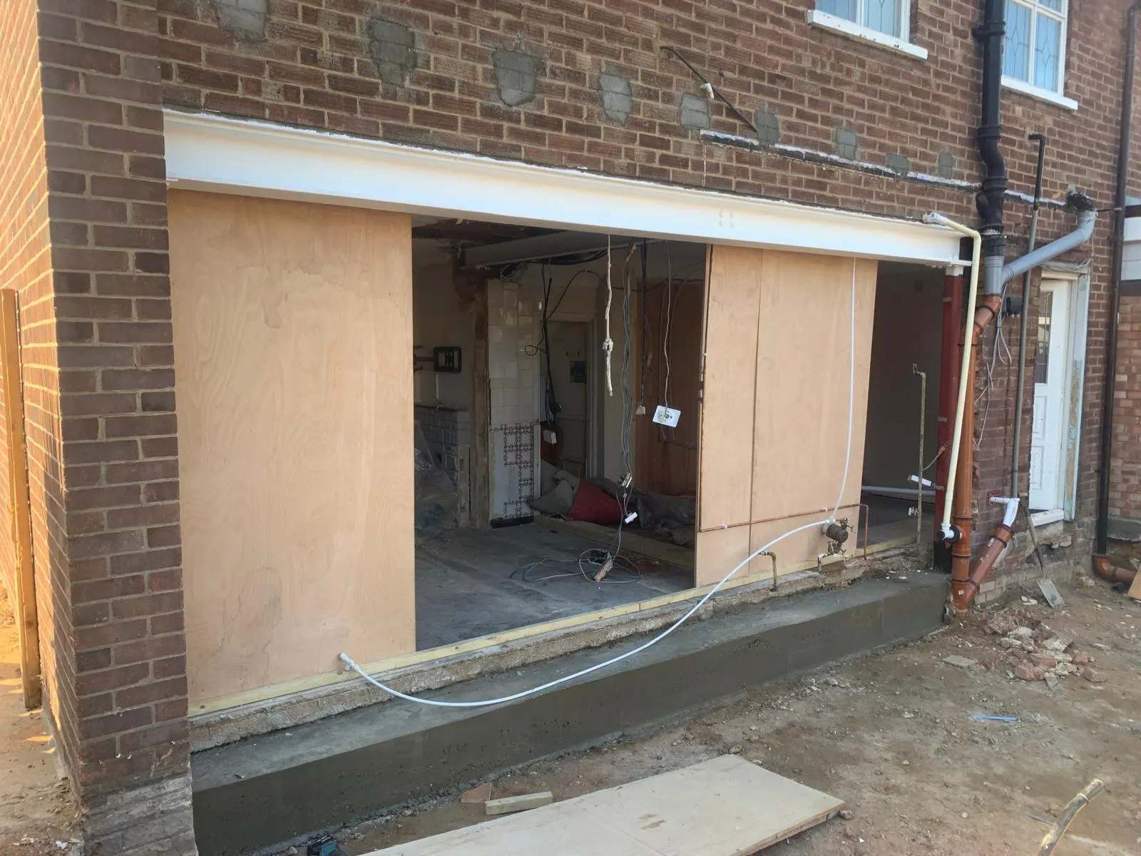 New structural opening formed in a brick elevation and boarded over concrete footings