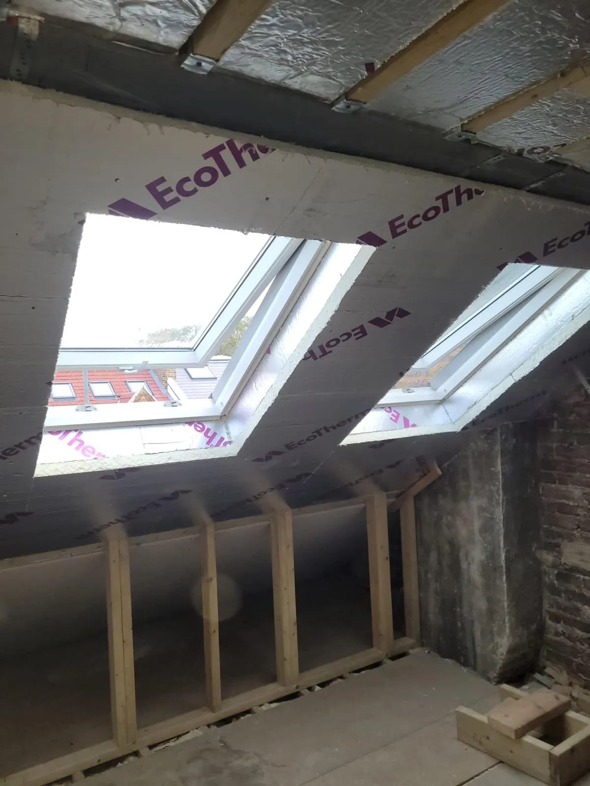 Loft conversion interior with rooflights fitted and rigid insulation boards installed