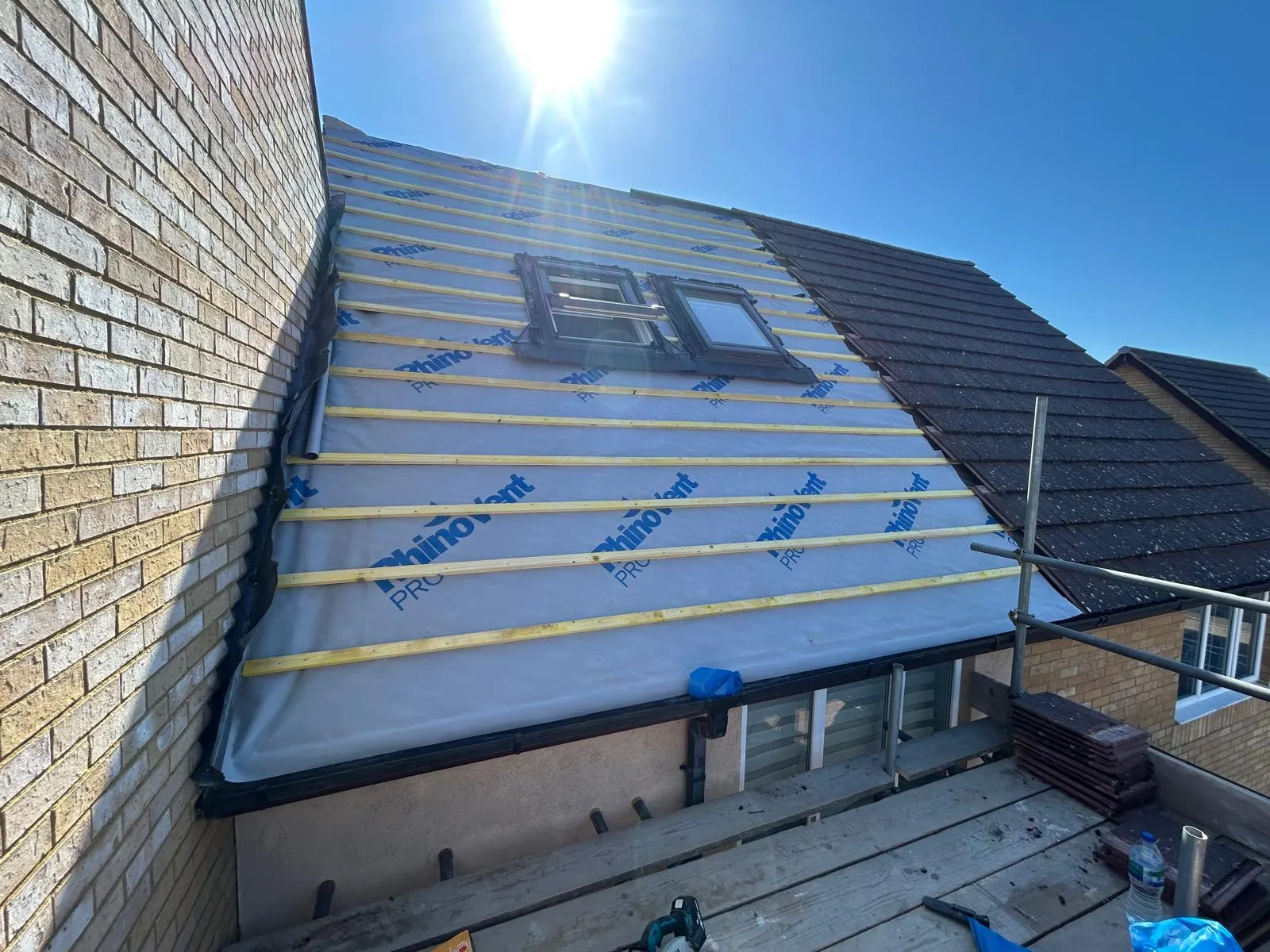 Breathable roof membrane and new battens fixed around two rooflights on a loft conversion